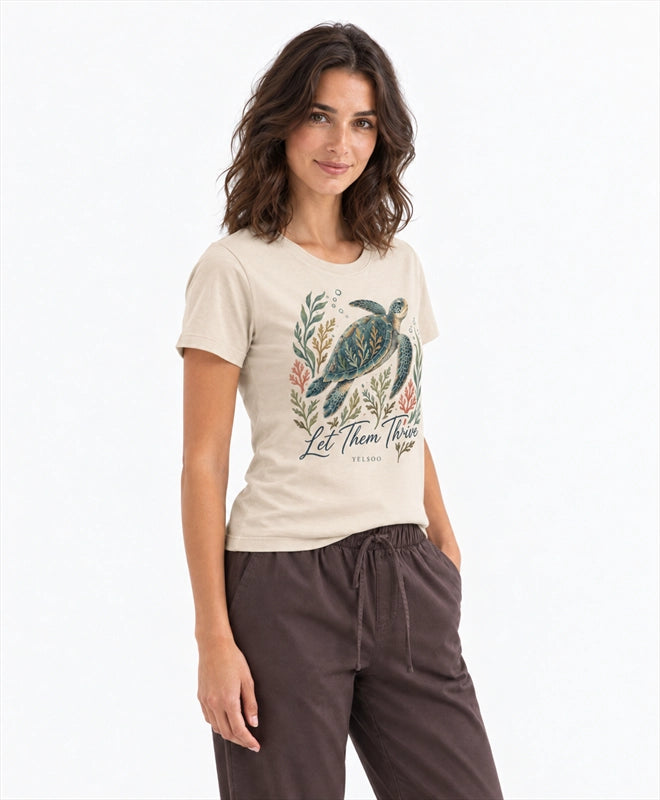 YELSOO women's Let Them Thrive Sea Turtle Graphic Tee in Sand — three-quarter model view